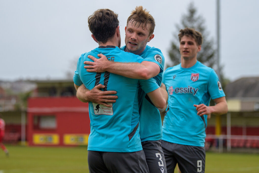 Flint players Burke and Jones celebrate during the 2024/25 JD Cymru Premier Play-Off Conference league fixture between Briton Ferry Llansawel A.F.C & Flint Town United F.C at Old Road Stadium, Port Talbot, Wales