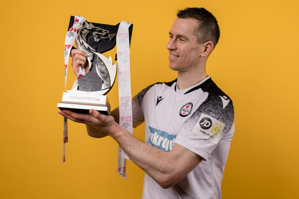 Bala Town's Chris Venables poses with the Nathaniel MG Cup trophy
