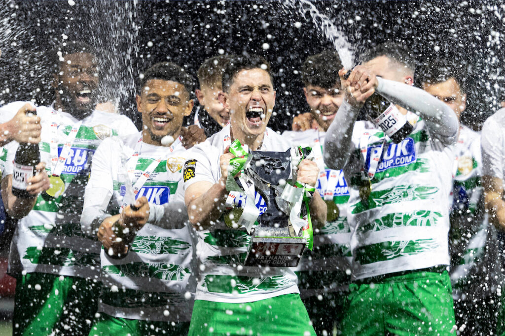 Daniel Redmond of TNS lifts the trophy after the 2024/25 Nathaniel MG Cup Final fixture between Aberystwyth Town FC & The New Saints FC at Latham Park, Newtown, Wales.