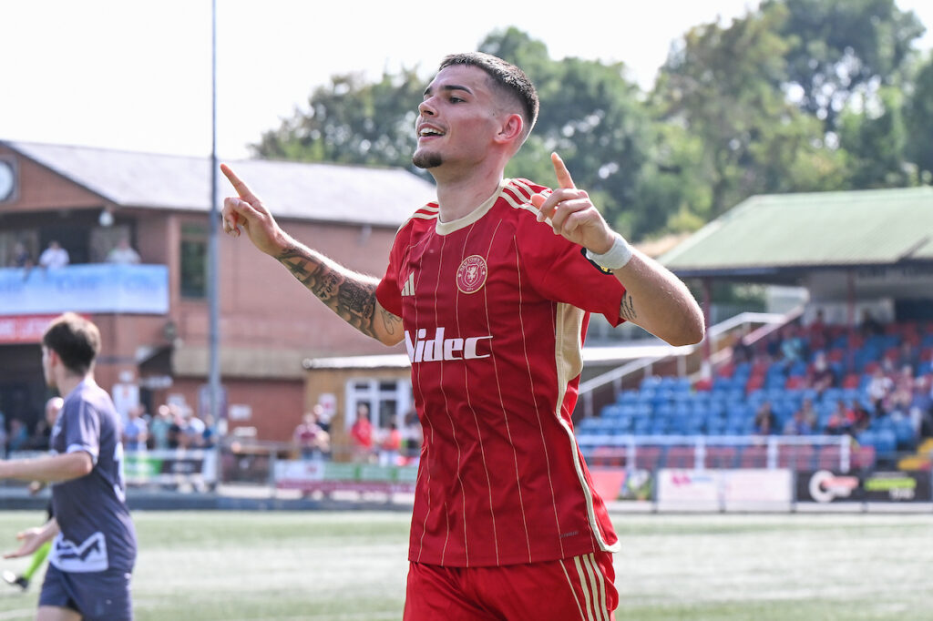 Louis Jacobs of Newtown celebrates his goal to make it 3-0 during the JD Cymru North game between Newtown and Flint Mountain at Latham Park in Newtown on the 16th August 2025