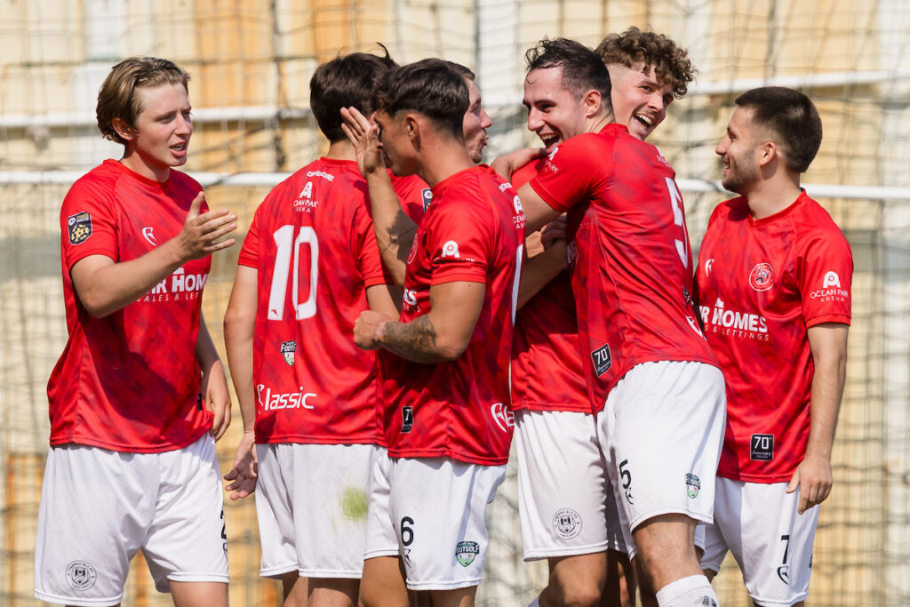 Caerau Ely's Jack Turner scores and celebrates during the 2025/26 JD Cymru South fixture between Cardiff Draconians FC and Caerau Ely FC at Lydstep Park, Cardiff, Wales