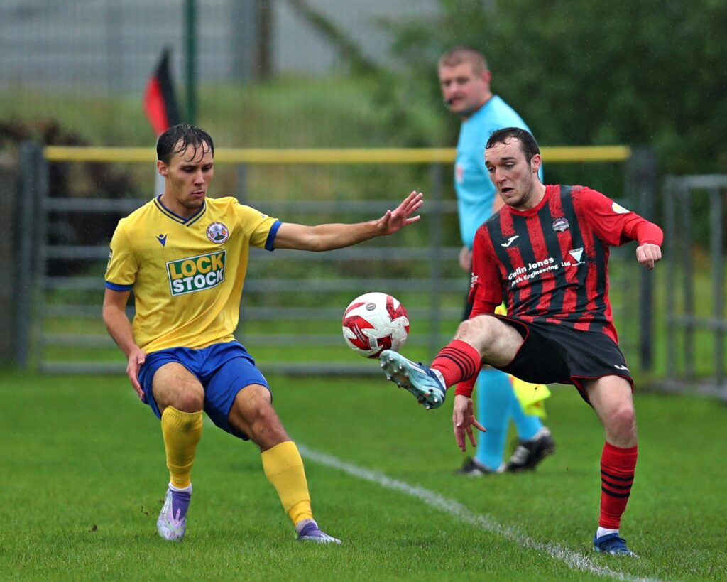 PORTHMADOG, GWYNEDD, WALES - 20th SEPTEMBER 2025 - Nathan Doforo of Denbigh pressures Dan Atkins of Porthmadog during CPD Porthmadog vs Denbigh Town in Round 1 of the JD Welsh Cup at Y Traeth, Porthmadog