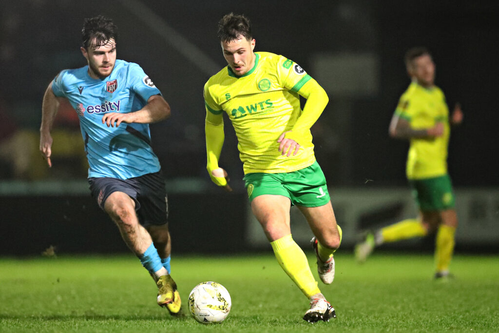 Ryan Sears of Caernarfon is pressured by Josh Jones of Flint Town United during Caernarfon Town vs Flint Town United in Round 22 of the JD Cymru Premier at The Oval, Caernarfon