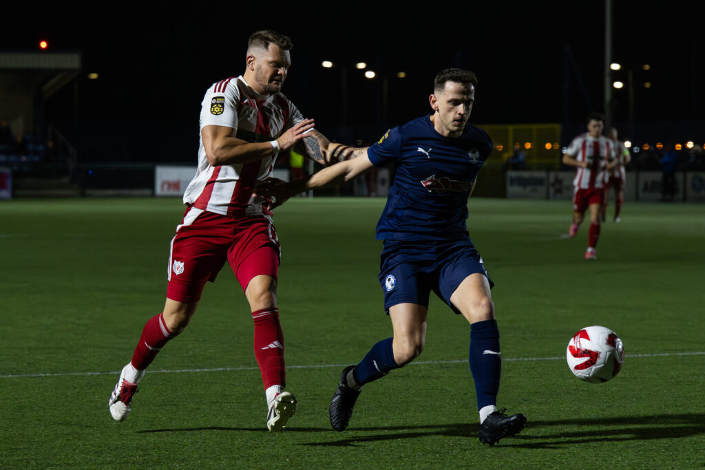 Nathan Williams of Airbus UK Broughton  holds of Jamie Breese of Holywell Town FC during the JD Cymru North game between Airbus UK Broughton and Holywell Town at The Hollingsworth Group Stadium in Broughton