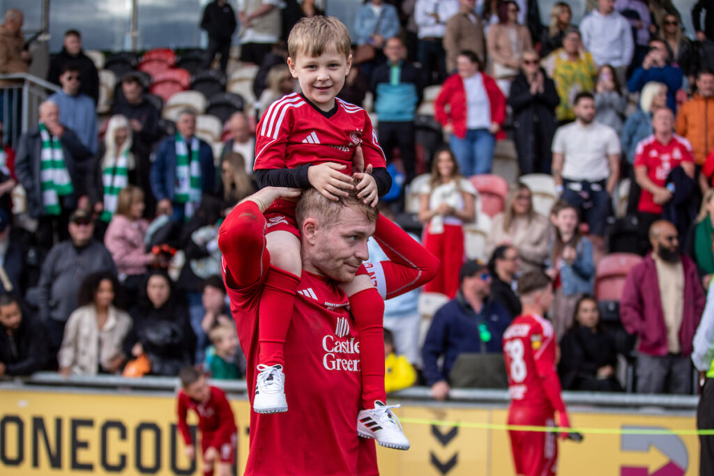 John Disney holds his son aloft at the JD Welsh Cup final at Newport County's Rodney Parade