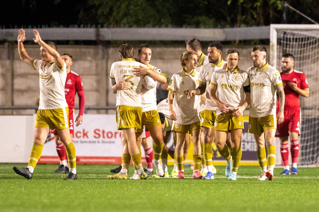 Caernarfon Town players celebrate Ryan Sears’ opening goal during the JD Cymru Premier fixture between Connah’s Quay Nomads and Caernarfon Town at the Essity Stadium, Flint, 23rd of September, Wales