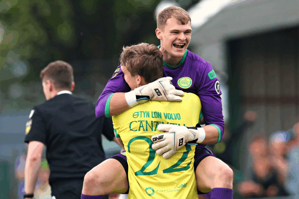 Swansea City's Ben Hughes celebrates with Caernarfon Town's Jake Canavan